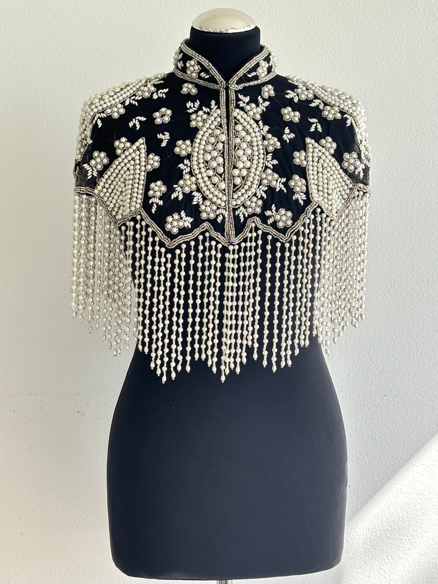 AVASA Black Pearl Beaded Fringe Capelet front view on black fabric base